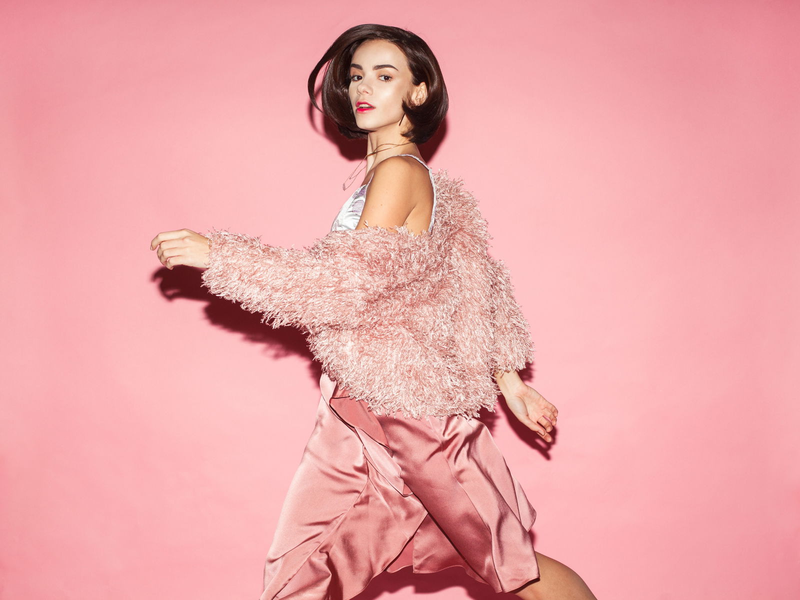 young fashion woman in pink clothes run on pink background | Live That Glow Your Complete Guide To Use A Curling Iron On Short Hair