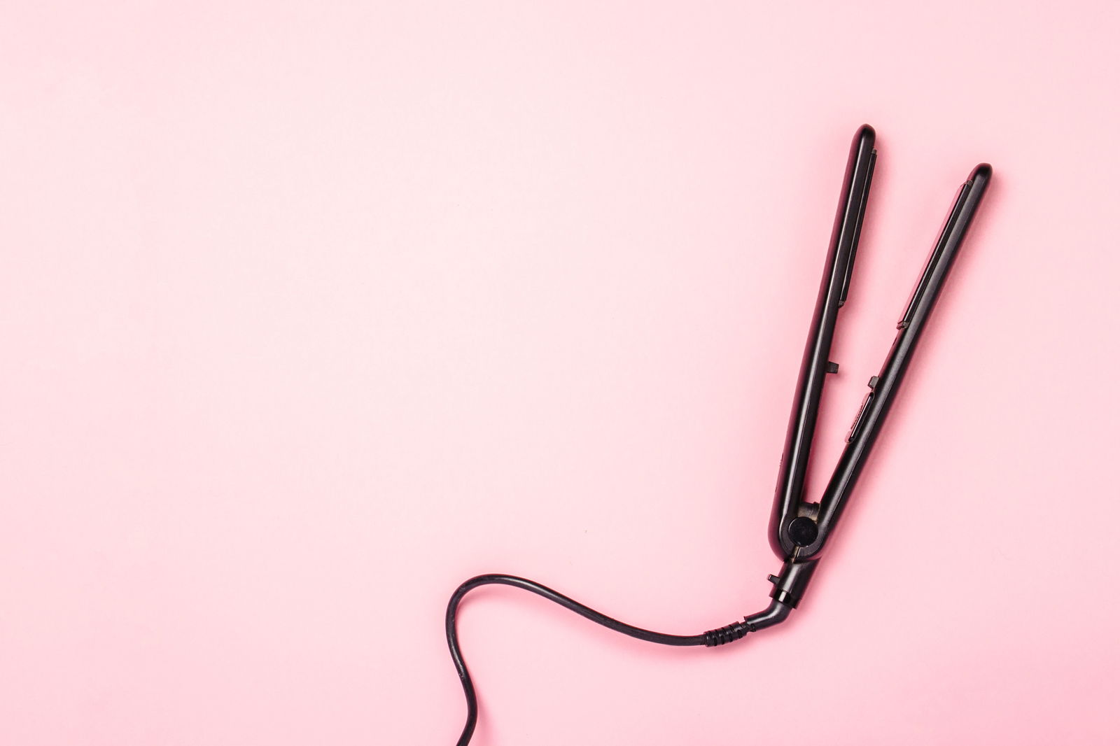 Hair straightener on a pink background Concept of hair care ha | Live That Glow Your Complete Guide To Use A Curling Iron On Short Hair