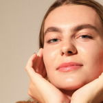 Young gorgeous woman, poses on white wall. Mind set concept. Mock-up. Vertical. High quality photo. Retinol ingredients skincare makeup