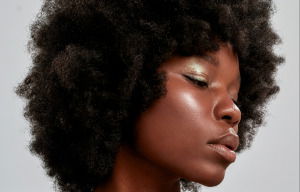 Woman with a dark skin tone showing how to pick the perfect blusher hair