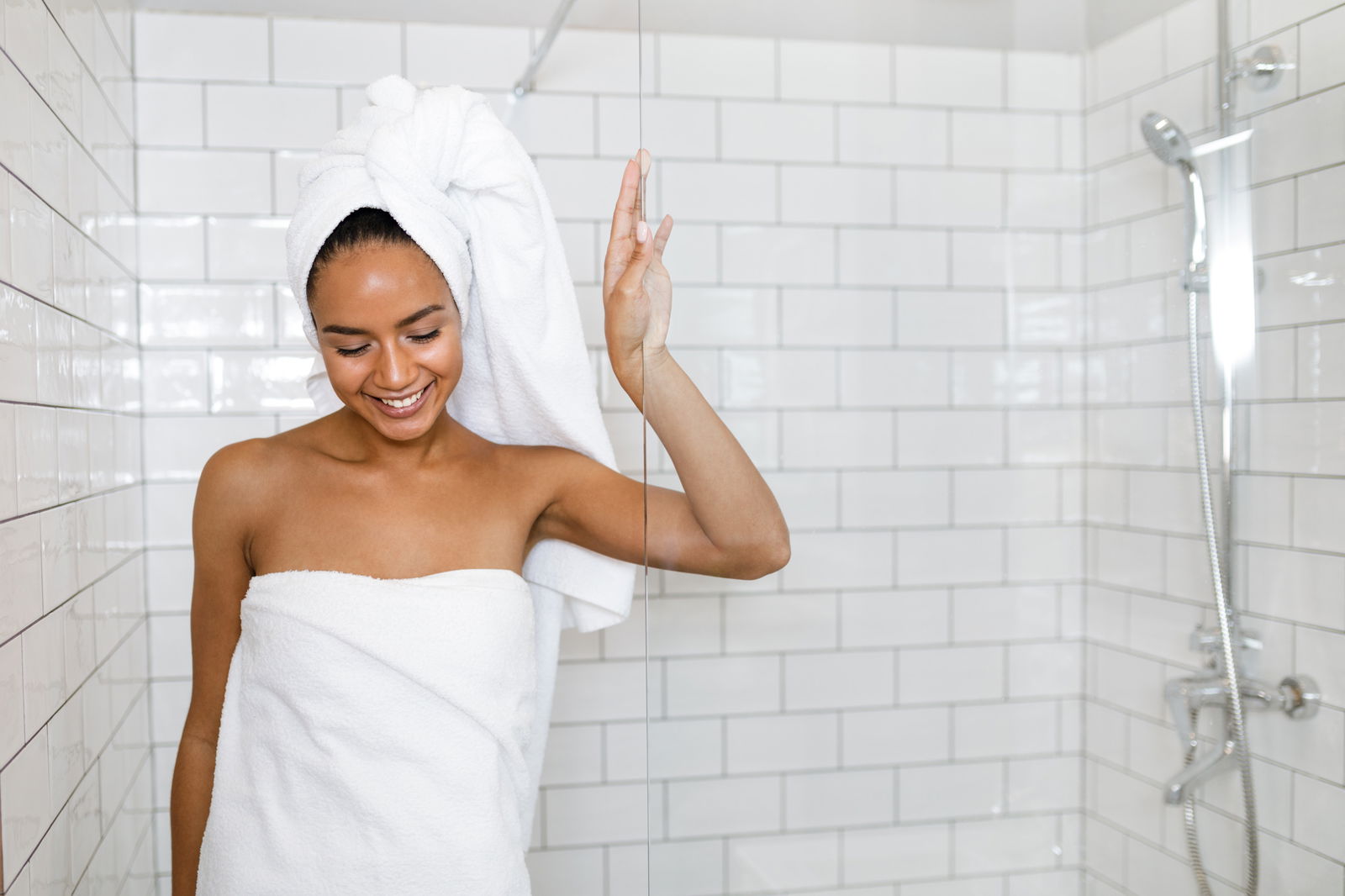 Woman coming out of the shower after using products on her back and shoulder acne