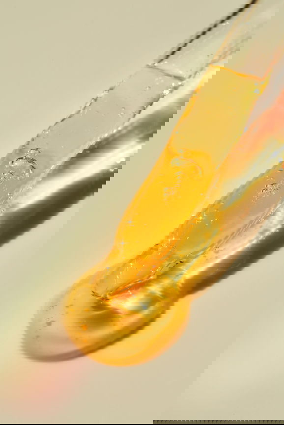 Dropper with beauty product for skincare routine over neutral background | Live That Glow Dropper with beauty product for skincare routine over neutral background.