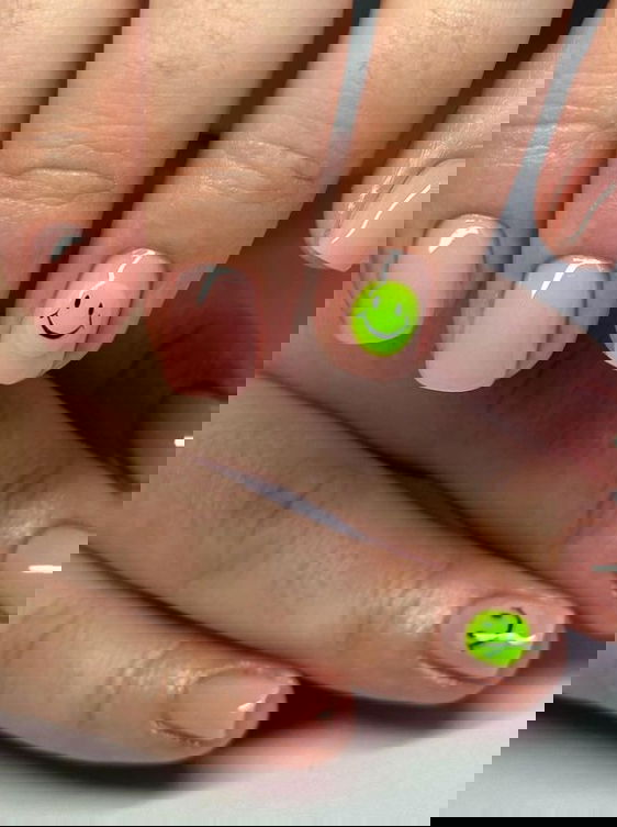 Short nude nails with lime green smiley face feature nails