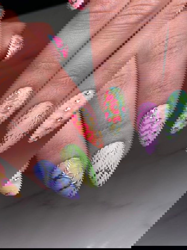 pastel rainbow nails with intricate designs and silver details