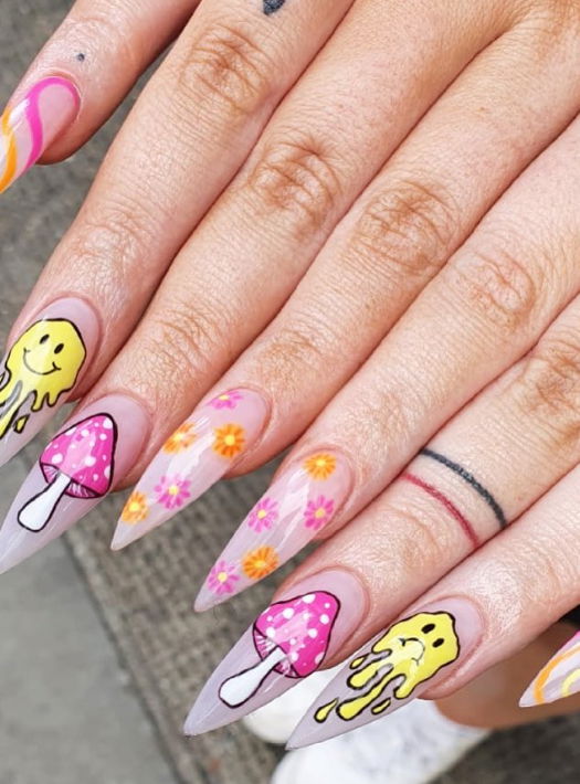 pink and yellow stiletto nails with smiley faces and swirls