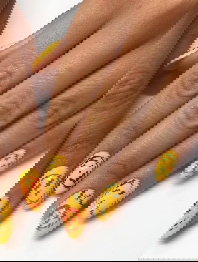 yellow nails with silly freehand smiley faces