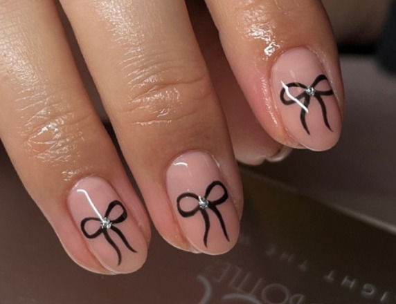 nude nails with black bows and silver gems