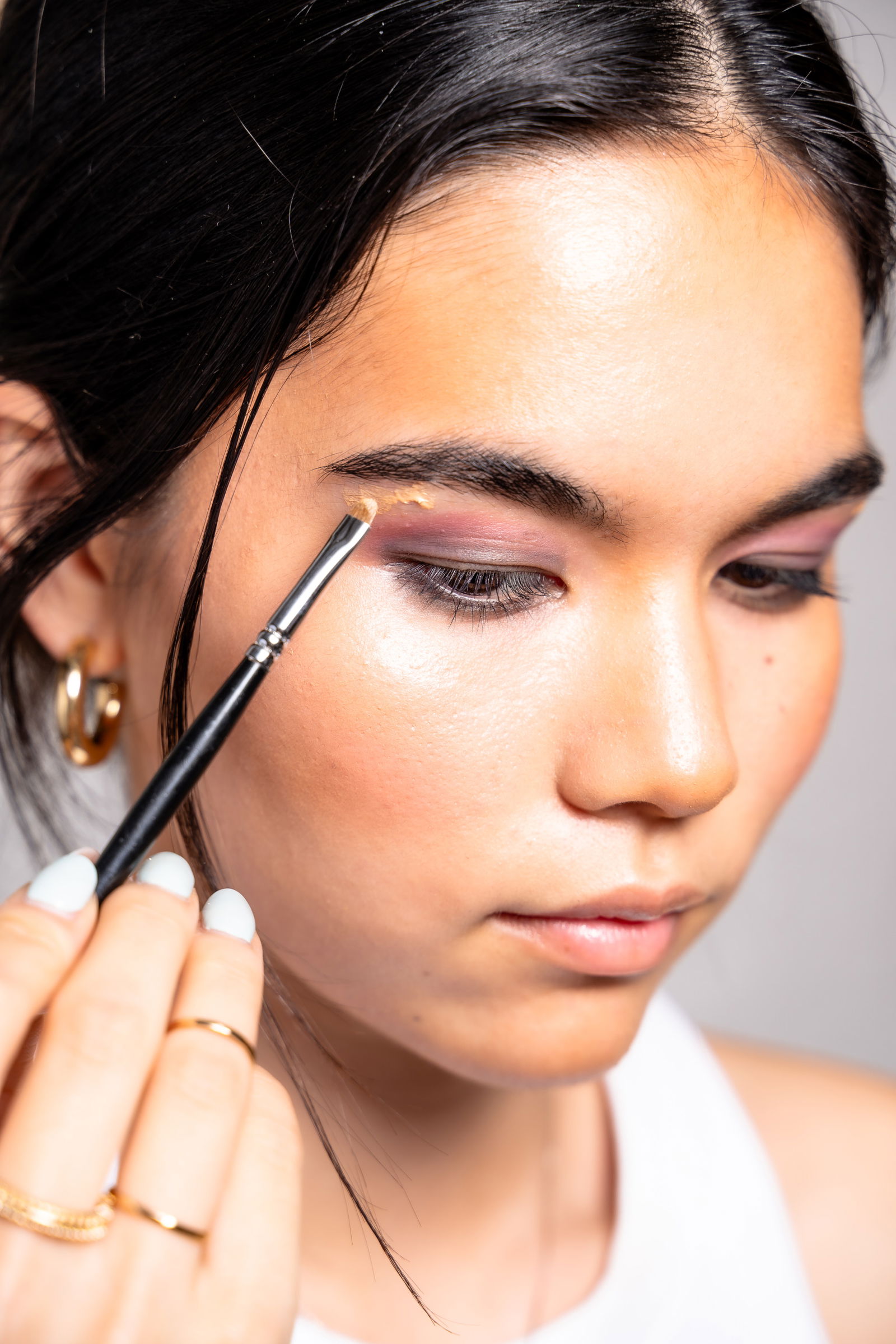 Girl showing where to apply highlighter to your brow bone