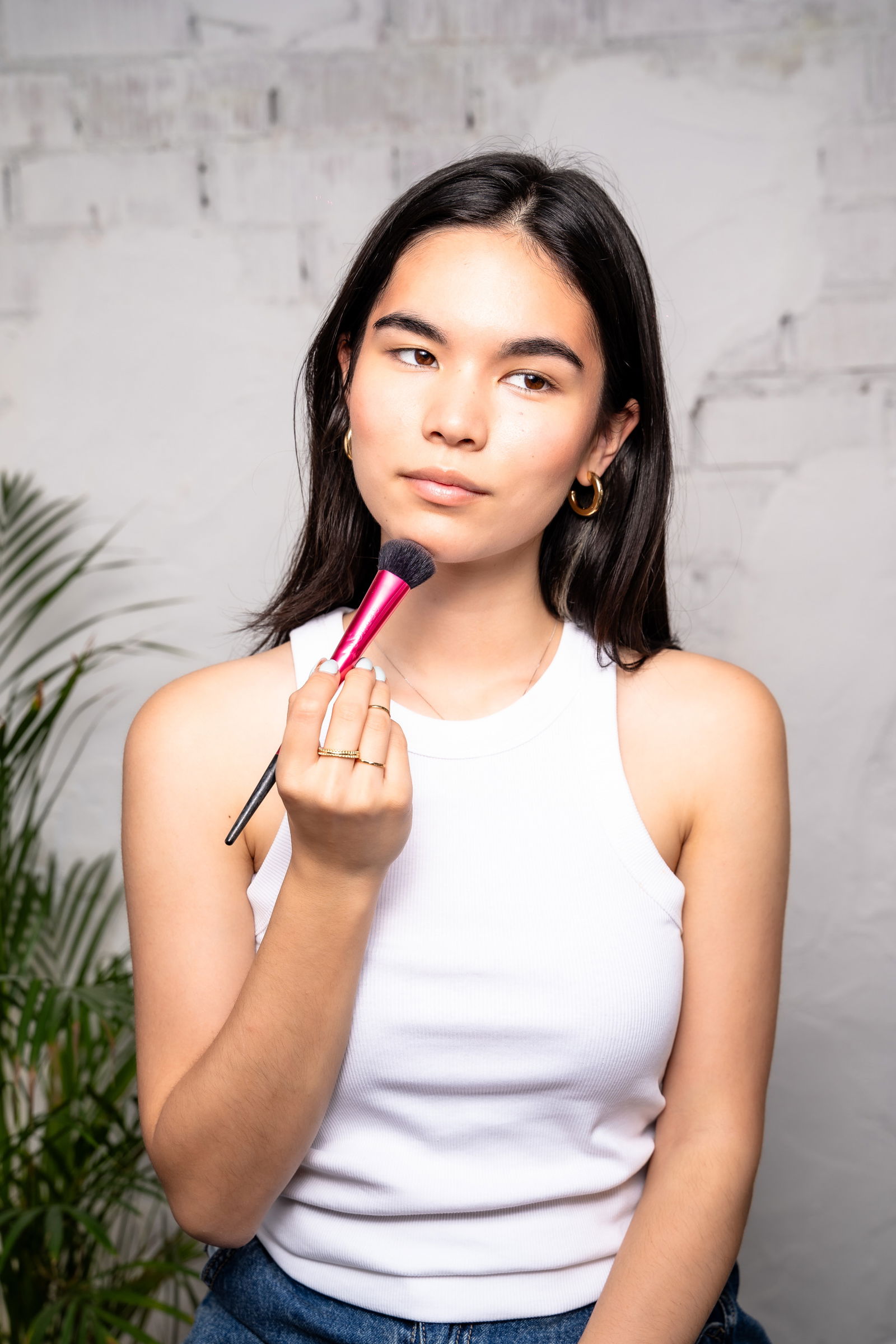 Girl showing how to apply bronzer to jawline