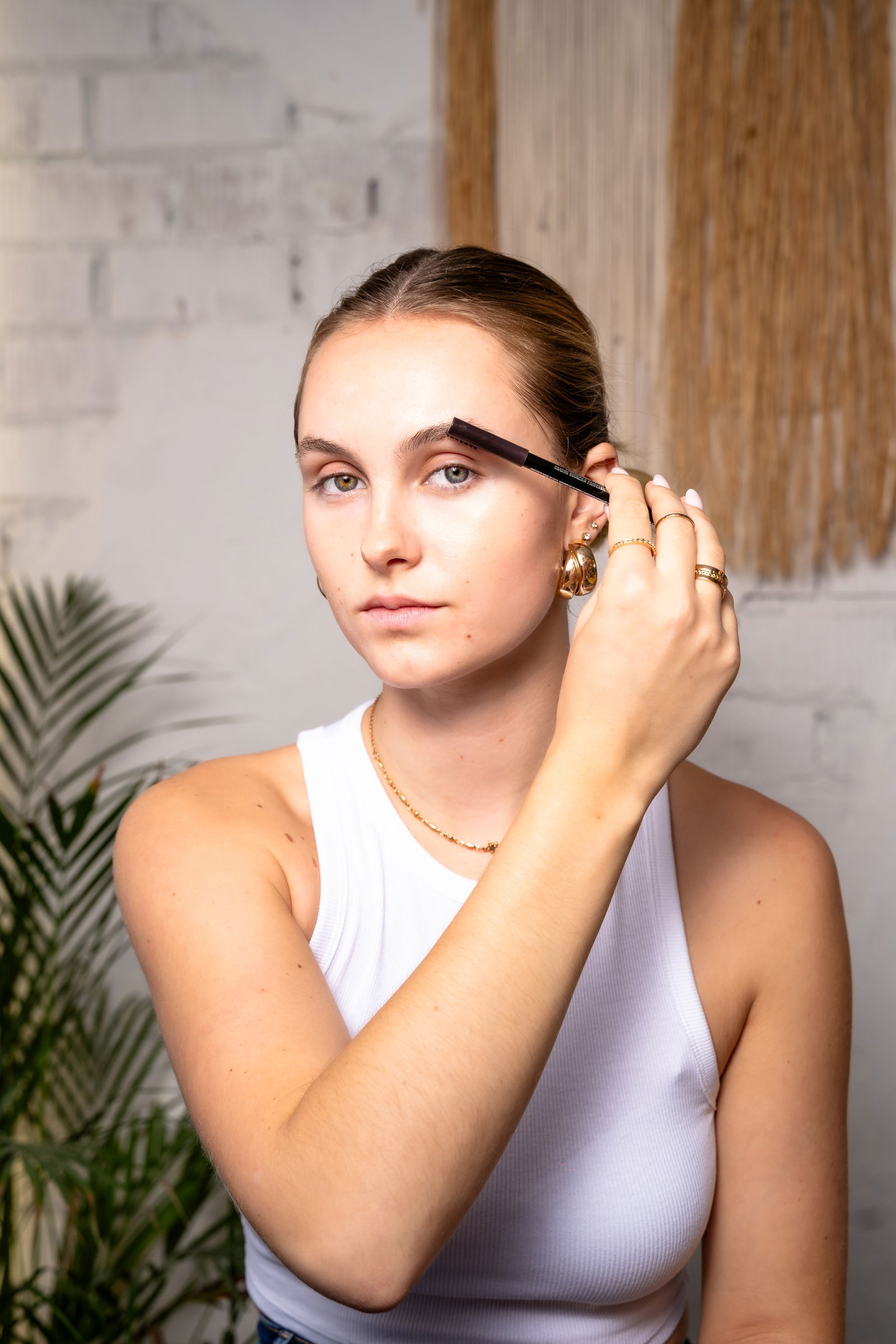 Girl showing how to comb eyebrows through before doing makeup