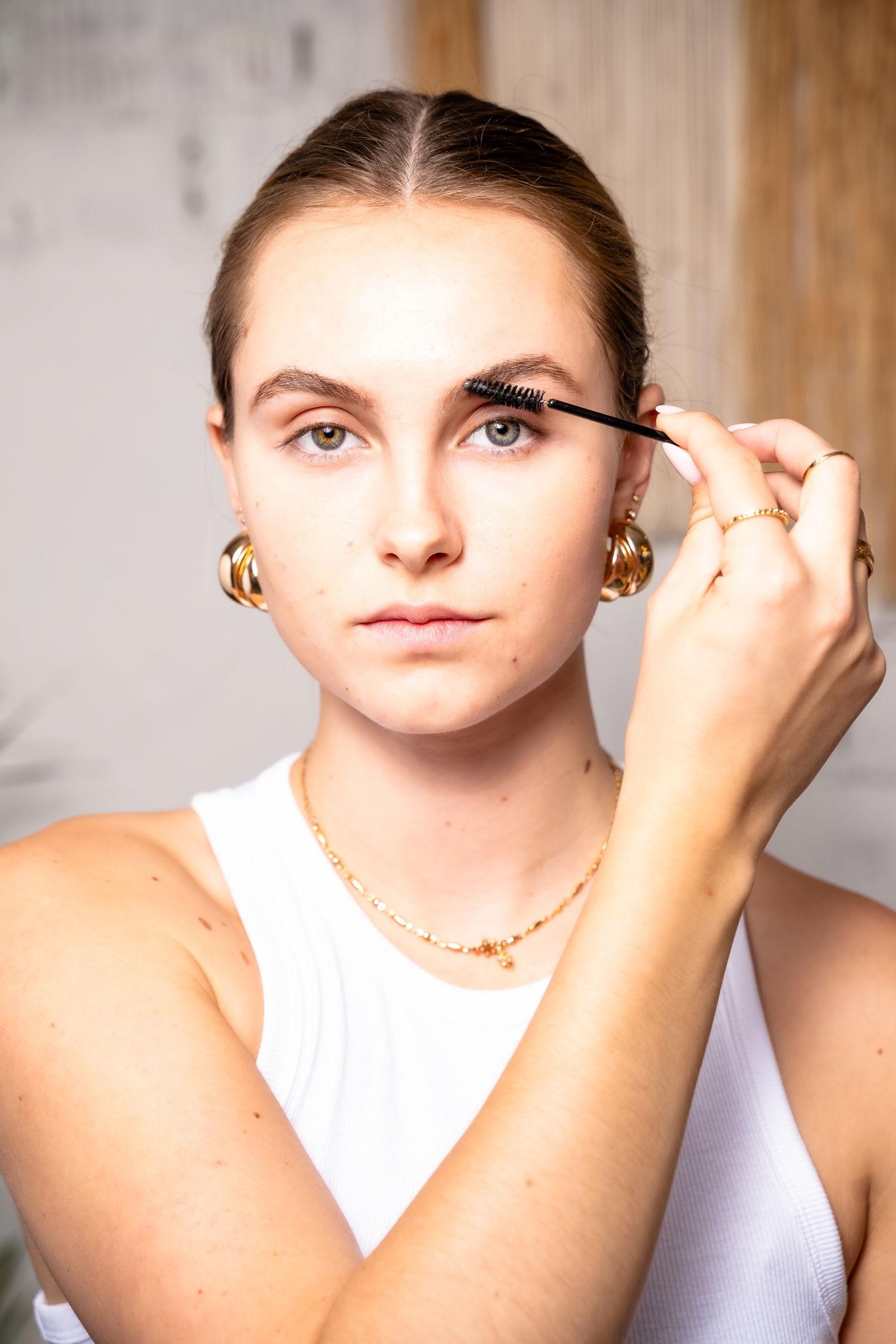 Girl showing how to blend her eyebrows after using makeup
