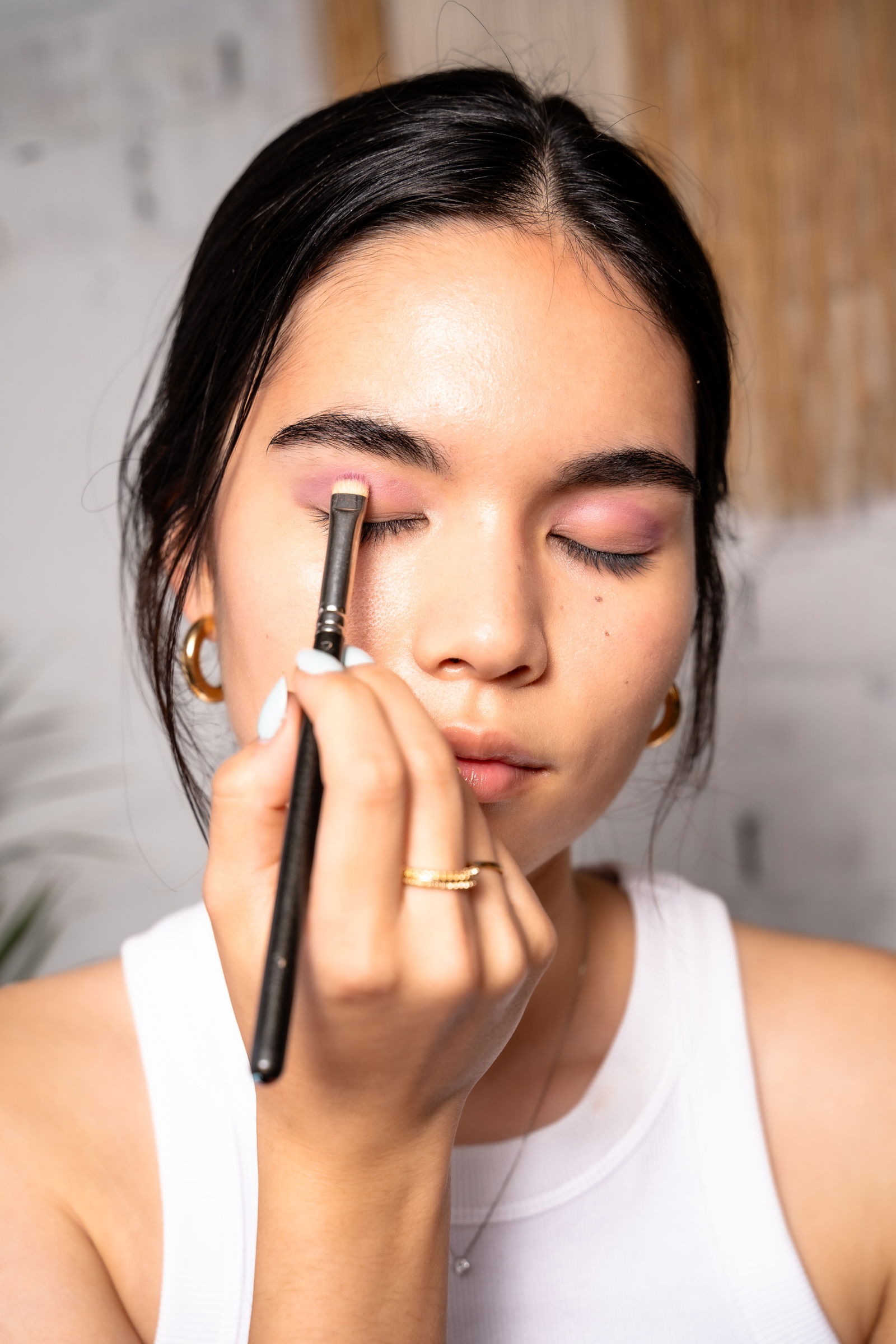 Girl showing how to apply eyeshadow to her crease for a smokey eye