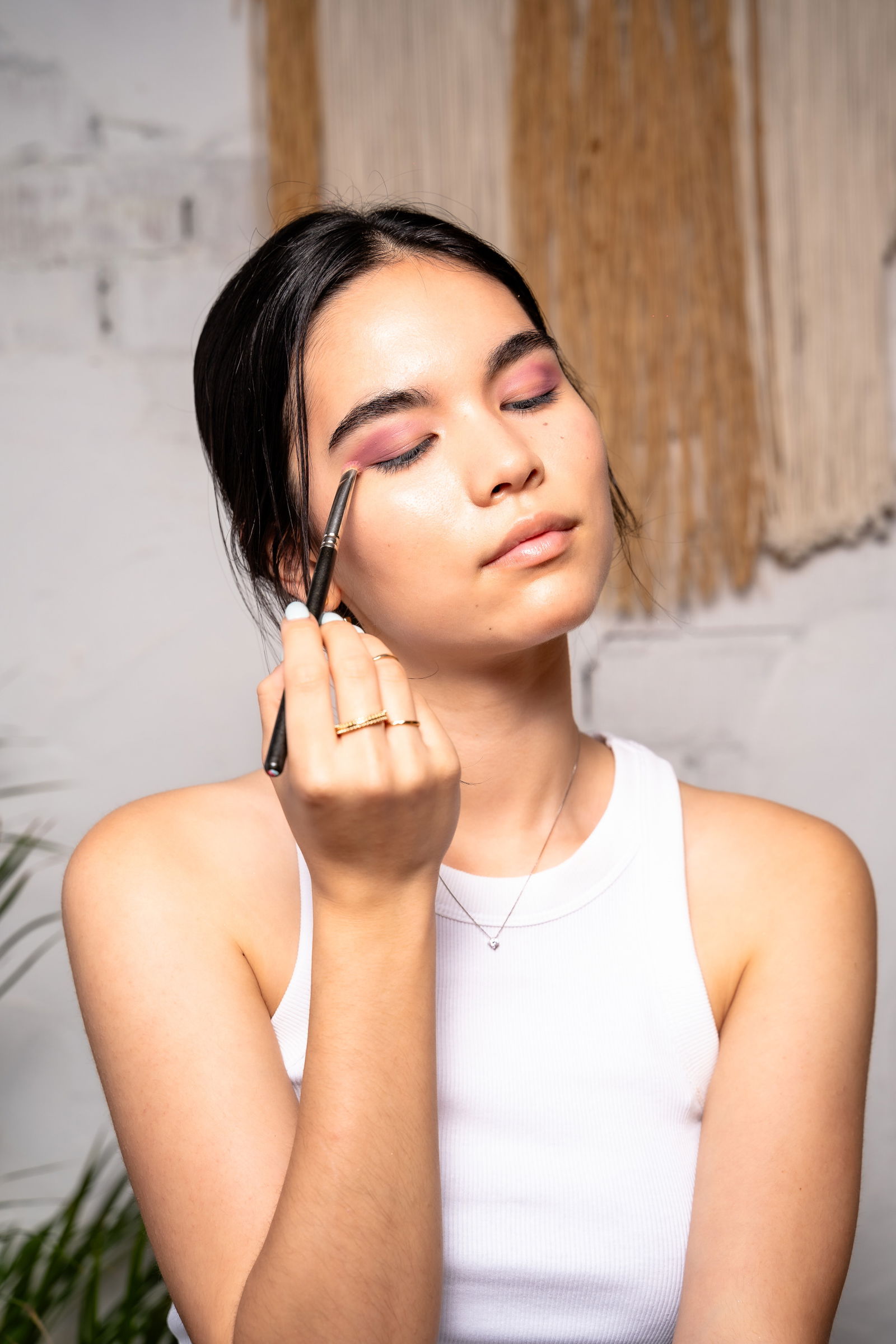 Girl showing how to apply eyeshadow to her outer corner for a smokey eye