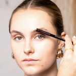 Girl applying makeup to eyebrows