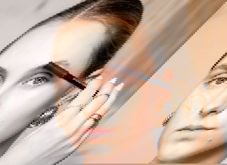 Girl applying makeup to eyebrows