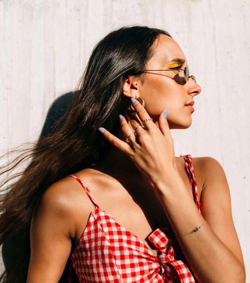 Portrait of brunette girl with long hair looking away in front of white background dip powder