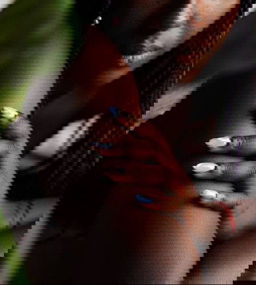 Black woman's hand and fingers with manicure and colorful nails dip powder nails