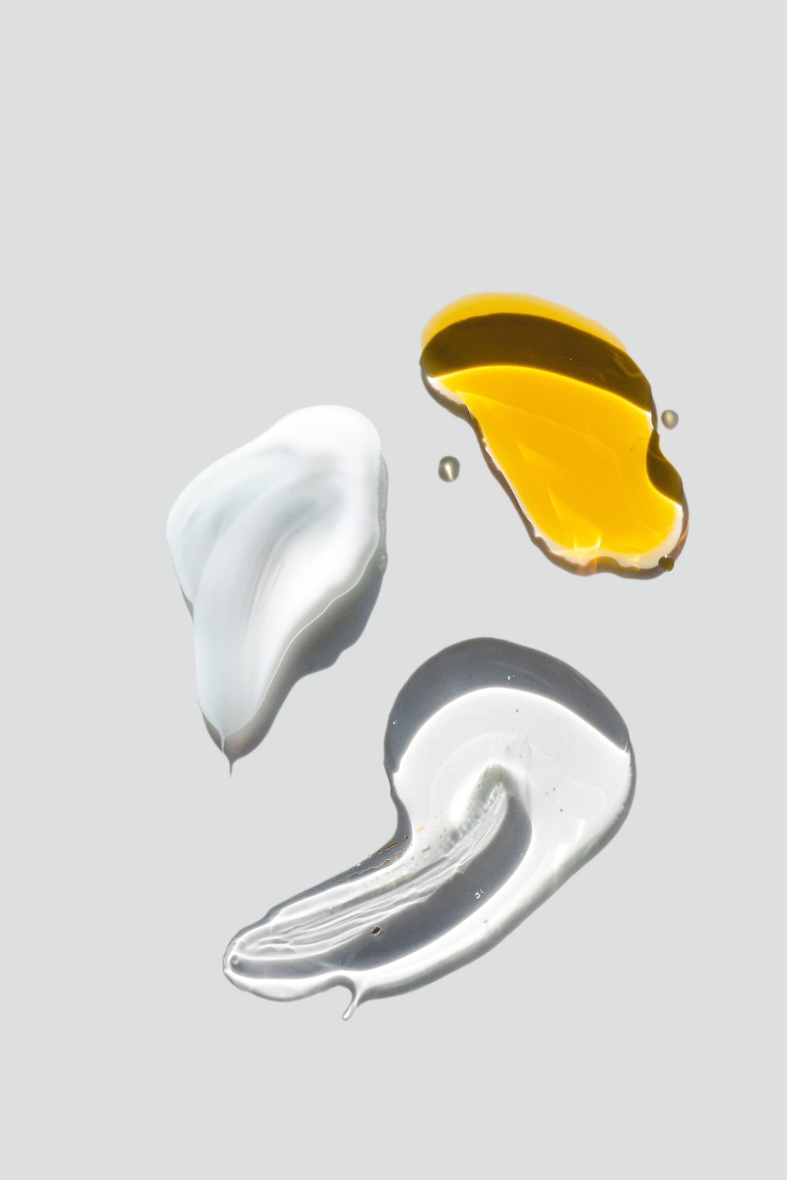 Flat lay macro photography of creams oils and make-up skincare products on white studio background | Live That Glow