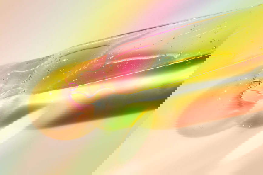 Dropper with beauty product for skincare routine over neutral background.