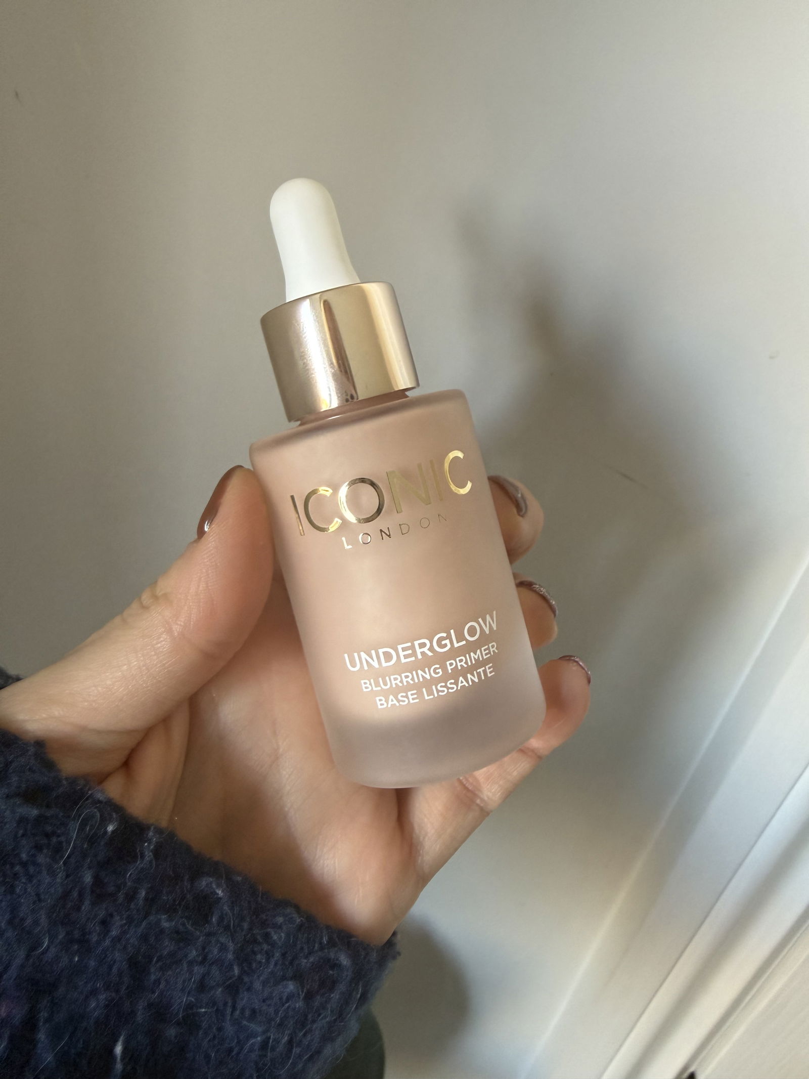 Iconic London Underglow Blurring Primer bottle in woman's hand